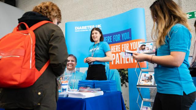 lady at a stand giving out diabetes leaflets