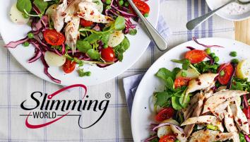 Two plates of watercress and new potato salad topped with mackerel on a blue and white striped table cloth.