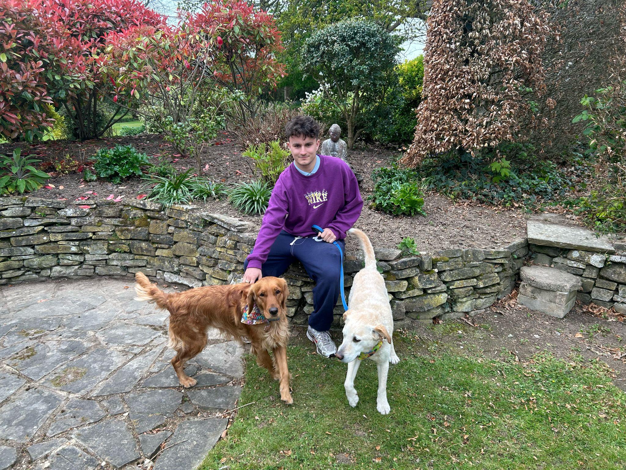 A young man pictured with two dogs 