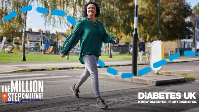 A lady in green walking across a road