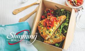 A small cardboard box with two sweetcorn fritter slices on top of rocket leaves and salsa.