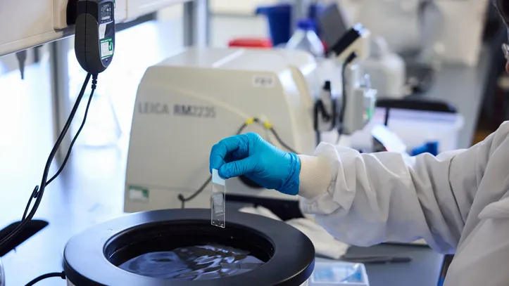 Scientist's gloved hand operating equipment in the lab