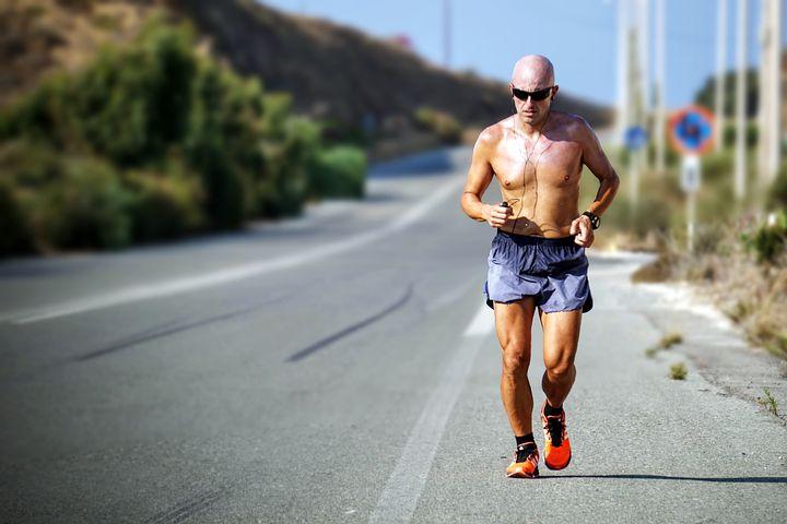 Man jogging shirtless by the road