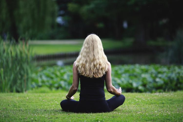 Woman meditating on grass